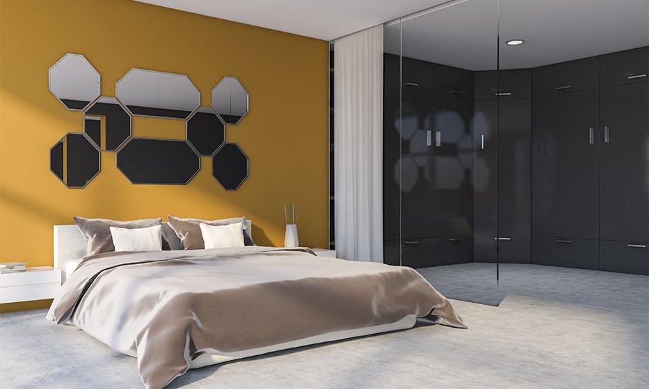 Mustard yellow bedroom with mirror decor and a full-length grey rug